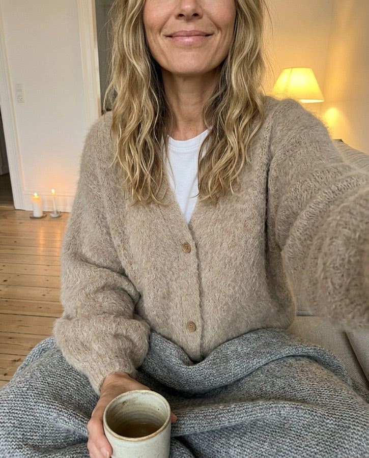 Kvinde i oversized mohair-cardigan i sofaen